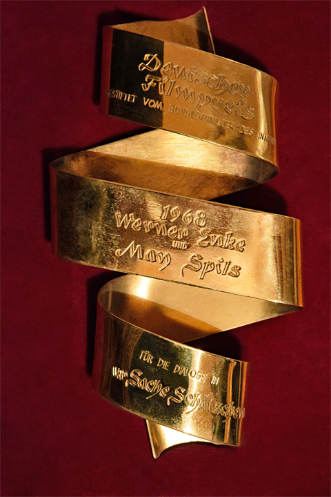 Deutscher Filmpreis 1968 als dreifach geringeltes und beschriftetes Filmband in Gold für Werner Enke und May Spils für die Dialoge in Zur Sache Schätzchen